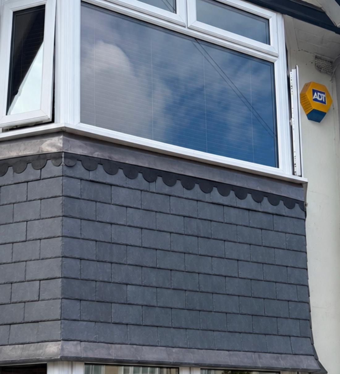 Slate-style hanging tiles beneath a bay window