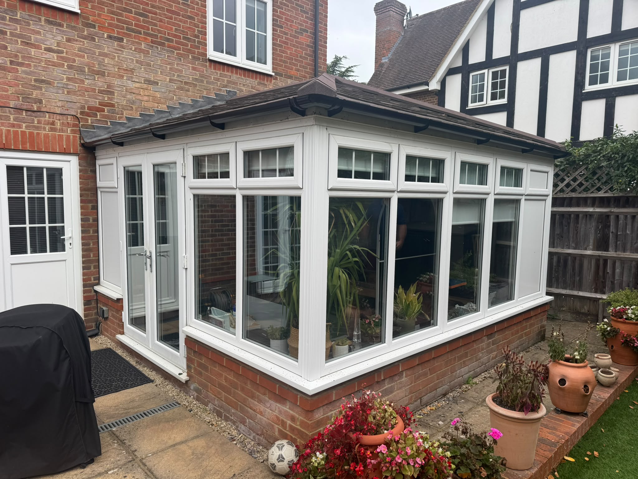 Conservatory with a dark roof and white window frames